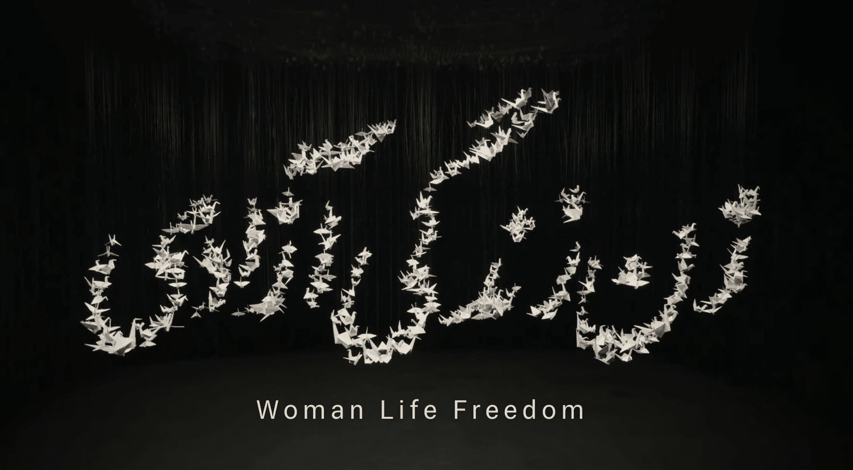 Woman Life Freedom spelt out using paper planes